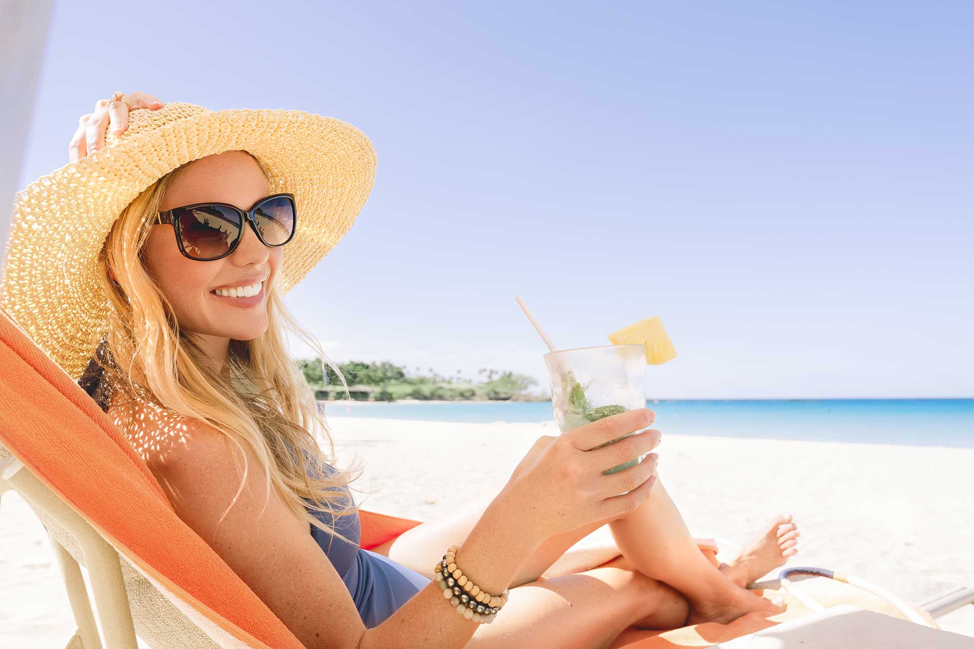 Women on beach in hawaii with beverage