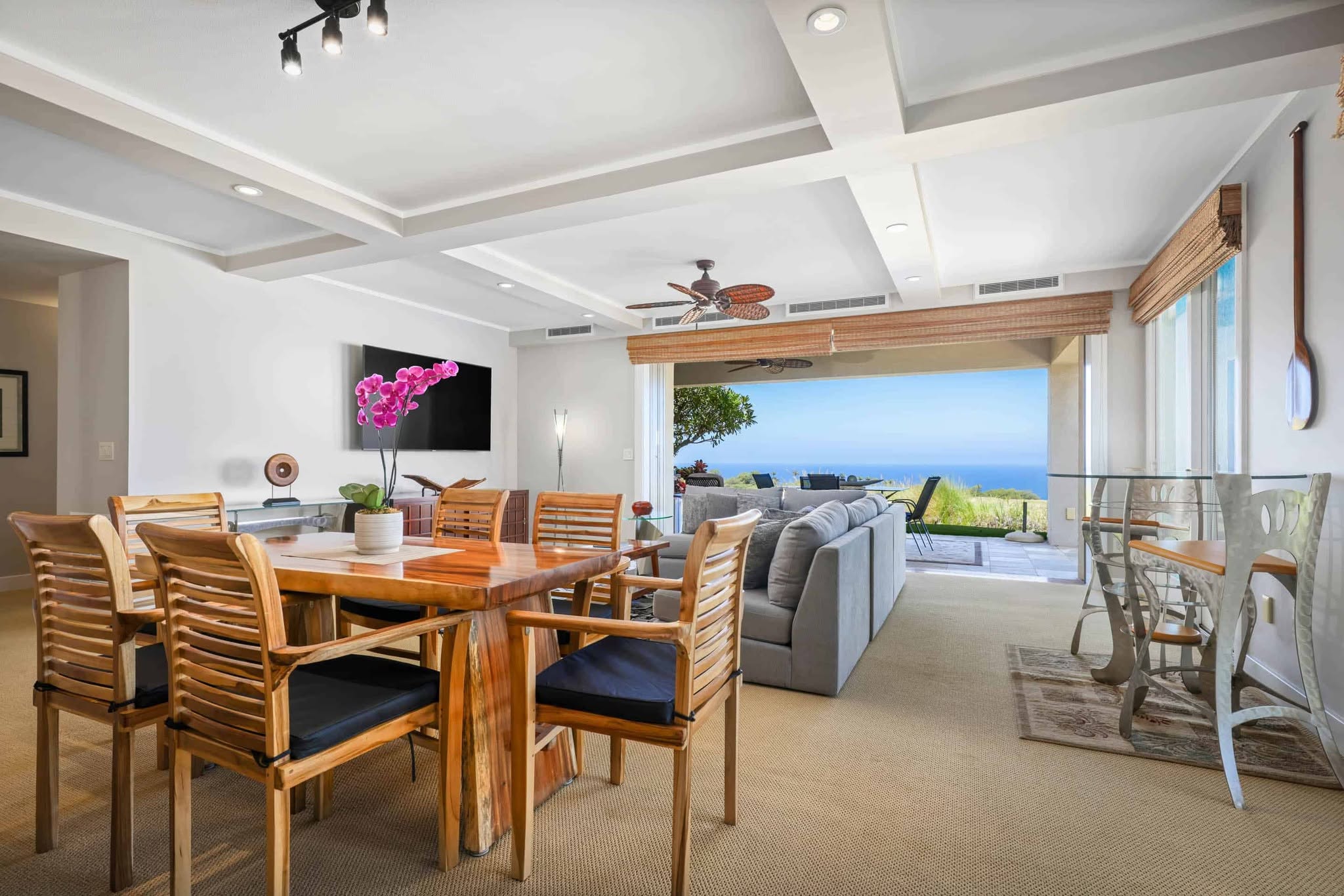 A cozy dining room featuring a table and chairs, with a stunning view of the ocean through large windows.